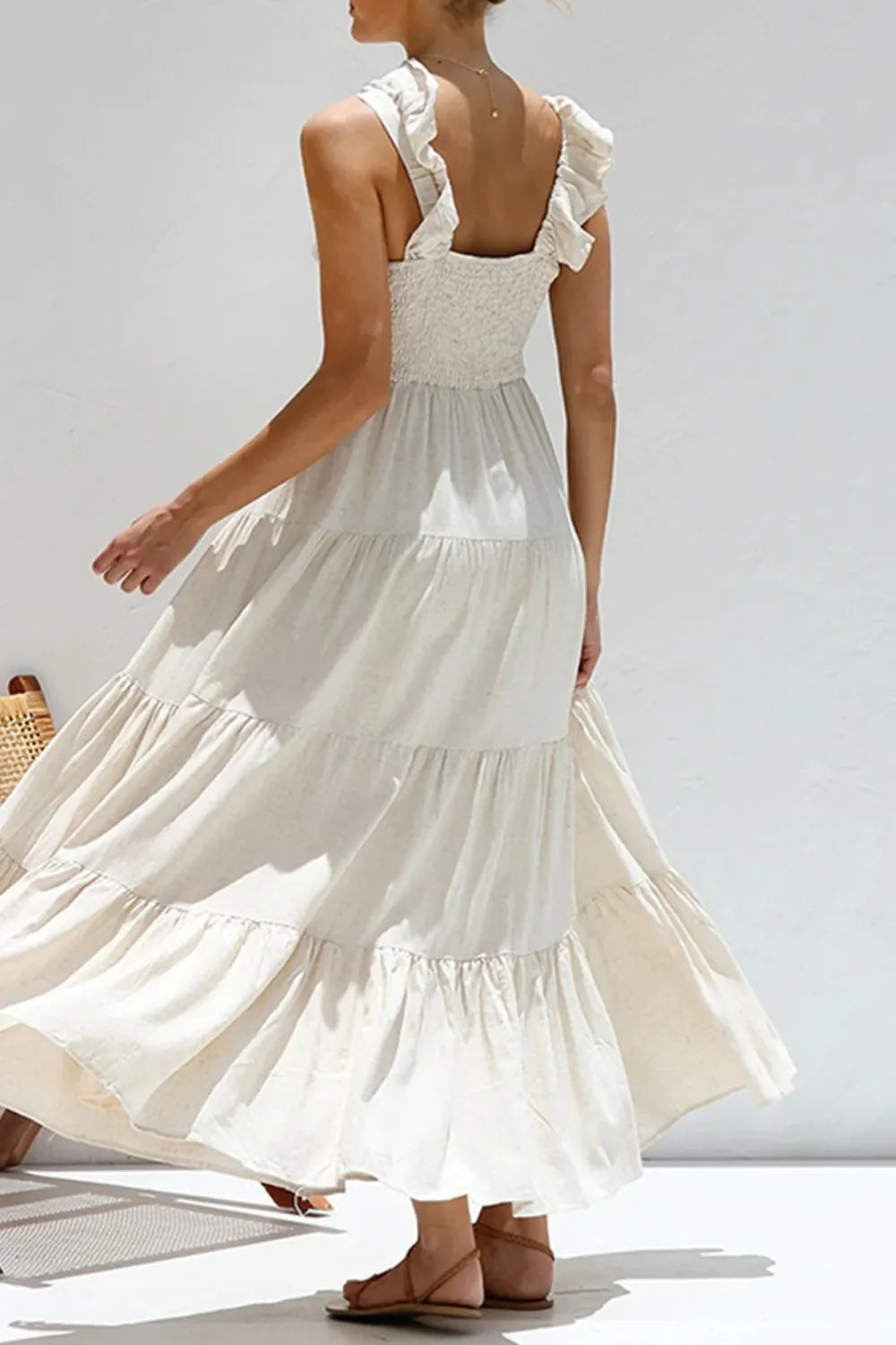 Back view of sustainable ruffled tiered dress in natural fiber cotton